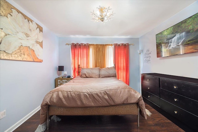 bedroom with wood finished floors and baseboards