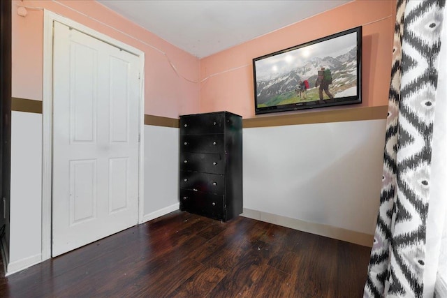 unfurnished bedroom with dark wood-style floors and baseboards