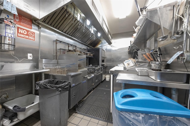 kitchen featuring oven, stainless steel counters, and tile patterned flooring