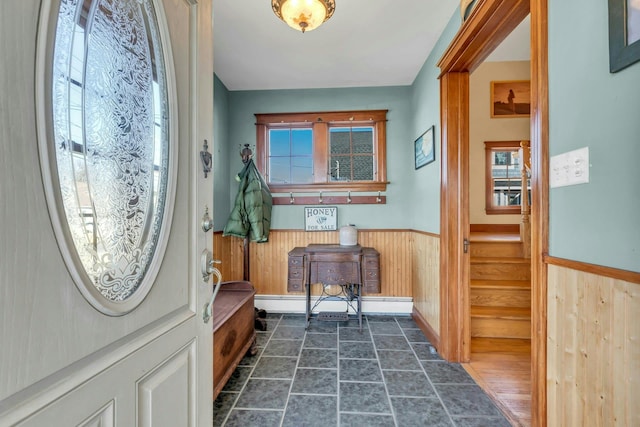 entryway featuring stairs, a healthy amount of sunlight, wood walls, and wainscoting