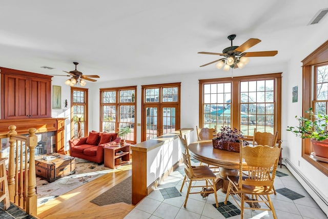 dining space with a baseboard heating unit, plenty of natural light, visible vents, and french doors