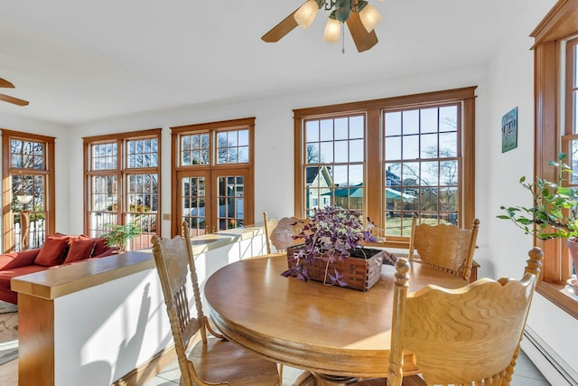 dining room with a baseboard heating unit and ceiling fan