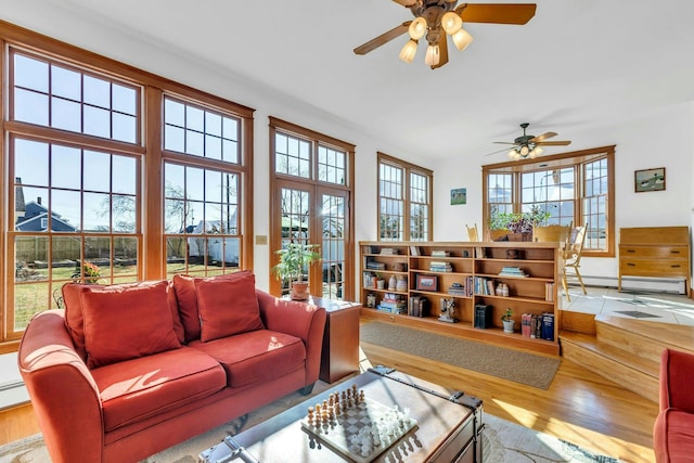 living room featuring baseboard heating, ceiling fan, and wood finished floors