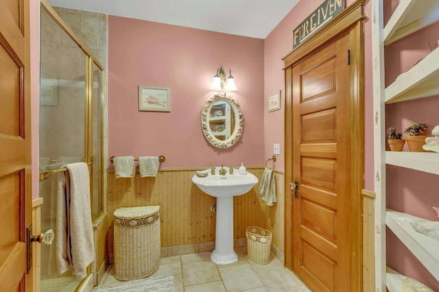 full bathroom featuring tile patterned floors, a stall shower, wainscoting, and wood walls