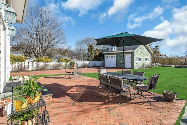 view of patio / terrace with an outbuilding, a fenced backyard, and outdoor dining space