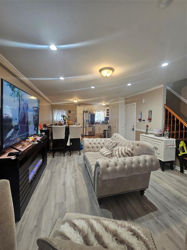 living room with recessed lighting, light wood-type flooring, and ornamental molding