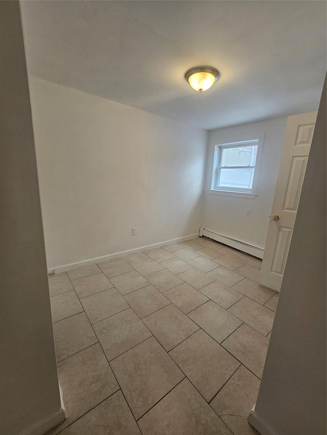 empty room featuring light tile patterned floors, baseboards, and a baseboard radiator