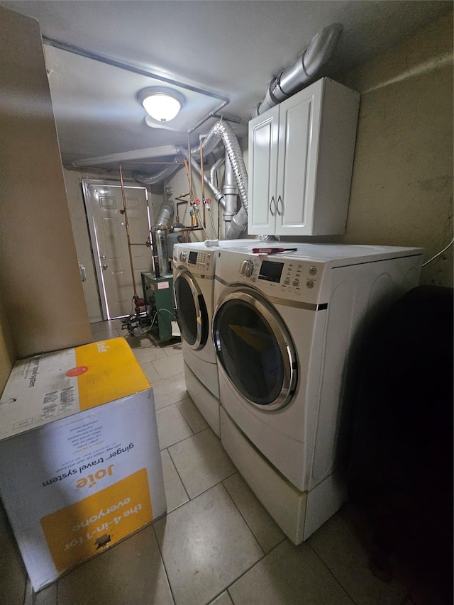 washroom with cabinet space, light tile patterned floors, separate washer and dryer, and a heating unit