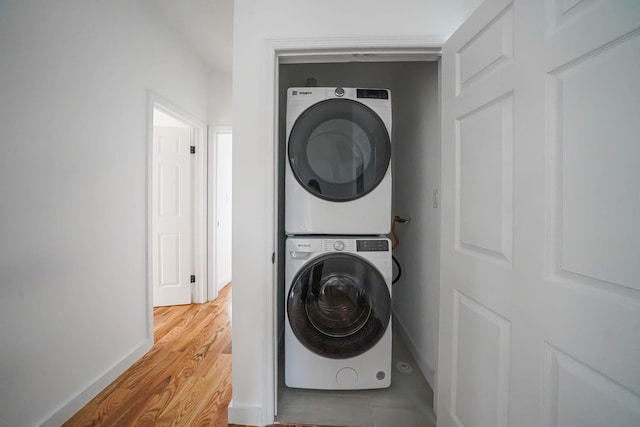 139-19 230th St, Laurelton, NY 11413 - laundry area with baseboards, laundry area, wood finished floors, and stacked washer and clothes dryer