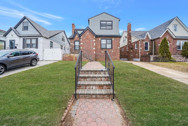 139-19 230th St, Laurelton, NY 11413 - english style home featuring a front yard, brick siding, fence, and a chimney