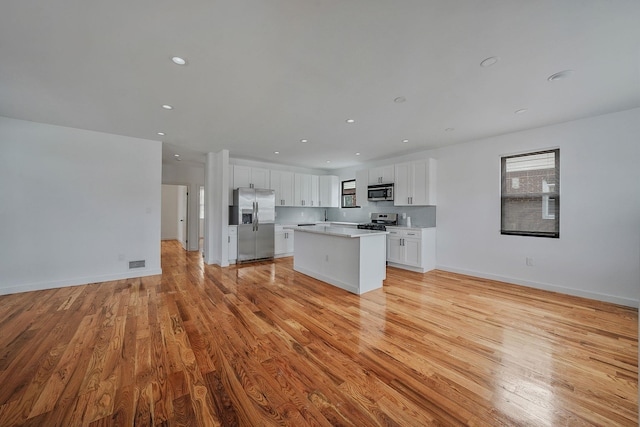 139-19 230th St, Laurelton, NY 11413 - kitchen with open floor plan, appliances with stainless steel finishes, light wood finished floors, and a kitchen island
