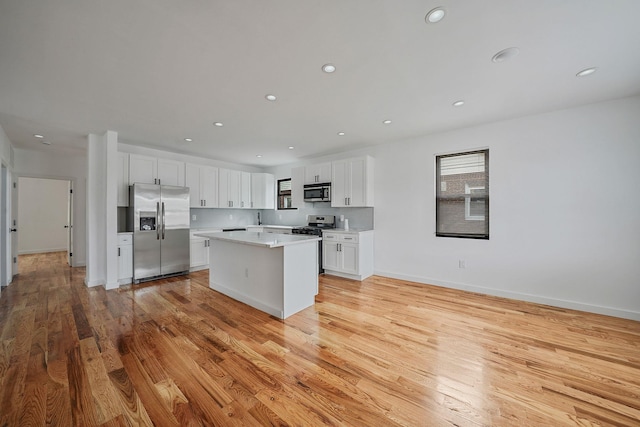 139-19 230th St, Laurelton, NY 11413 - kitchen with light wood-style flooring, a center island, light countertops, white cabinets, and stainless steel appliances