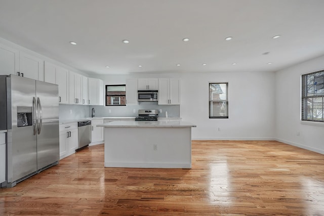 139-19 230th St, Laurelton, NY 11413 - kitchen with stainless steel appliances, light wood-style floors, white cabinets, and a kitchen island