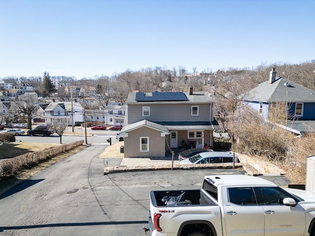 traditional-style house featuring roof mounted solar panels, washer / clothes dryer, and a residential view