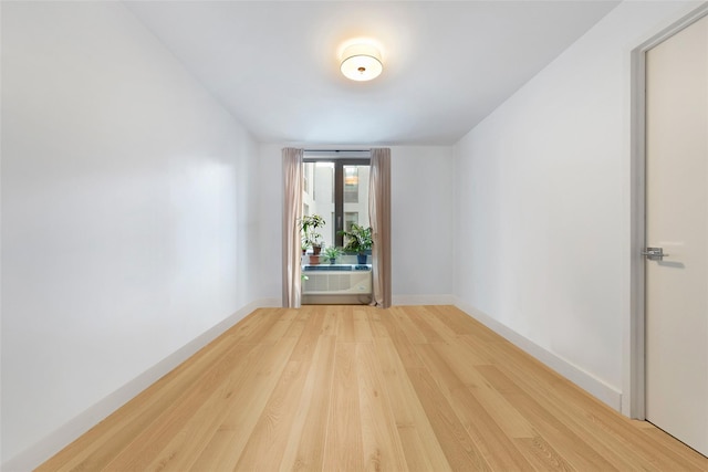 spare room with light wood-type flooring and baseboards