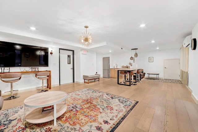 living area with recessed lighting, baseboards, light wood finished floors, and a wall mounted AC