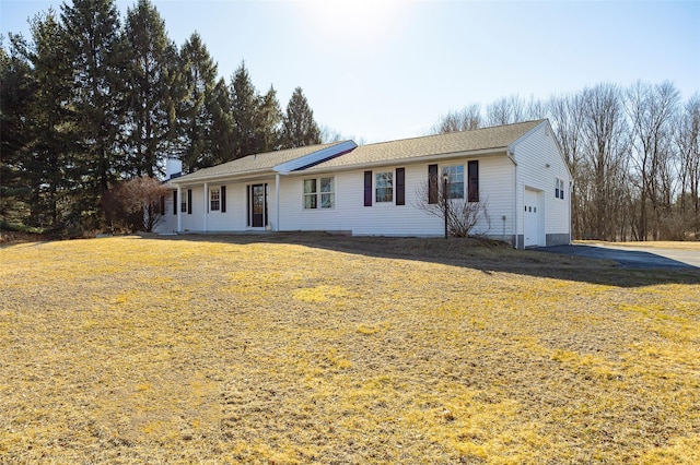 ranch-style house with solar panels, a front lawn, and driveway