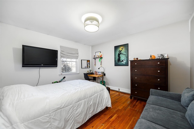 bedroom featuring baseboard heating and wood finished floors