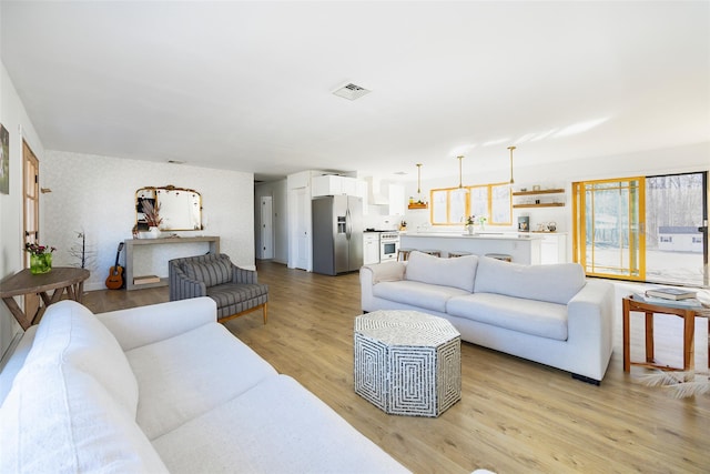 living area featuring light wood finished floors and visible vents