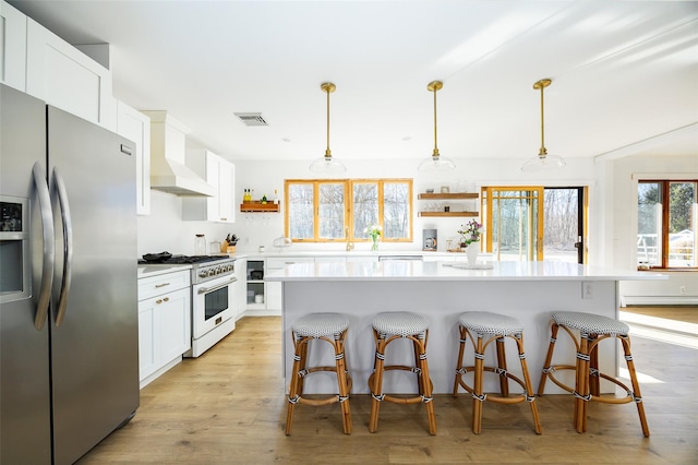 kitchen featuring visible vents, open shelves, stainless steel appliances, light wood finished floors, and custom exhaust hood