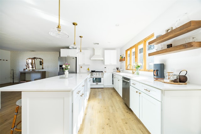 kitchen featuring open shelves, wall chimney range hood, light wood-type flooring, appliances with stainless steel finishes, and a sink