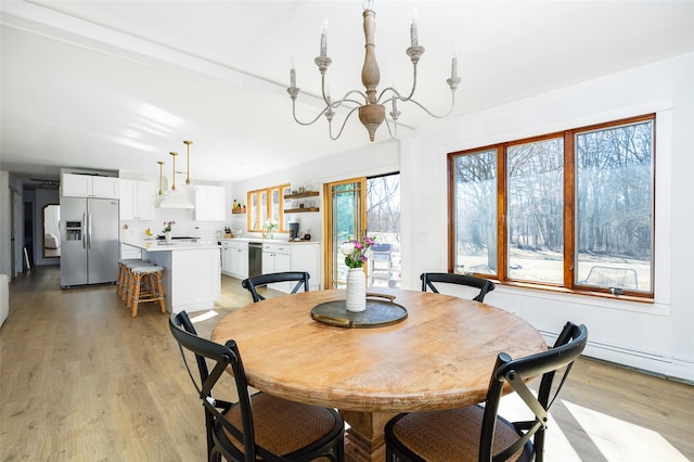 dining room with a notable chandelier and light wood finished floors