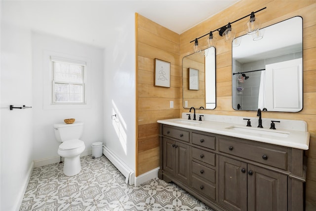 full bath featuring double vanity, toilet, a baseboard radiator, and a sink