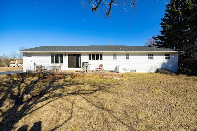 rear view of property featuring a yard, a shingled roof, and a patio area