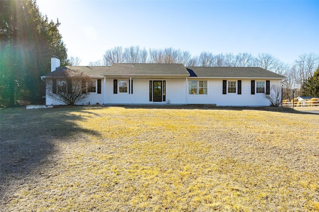 ranch-style home featuring a front lawn and a chimney