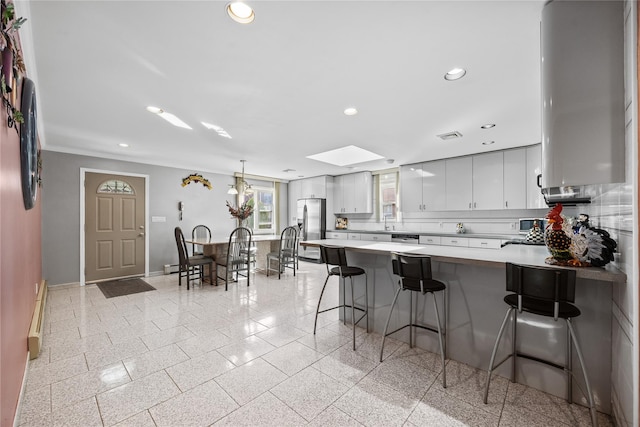 kitchen featuring recessed lighting, baseboards, a peninsula, and stainless steel refrigerator with ice dispenser