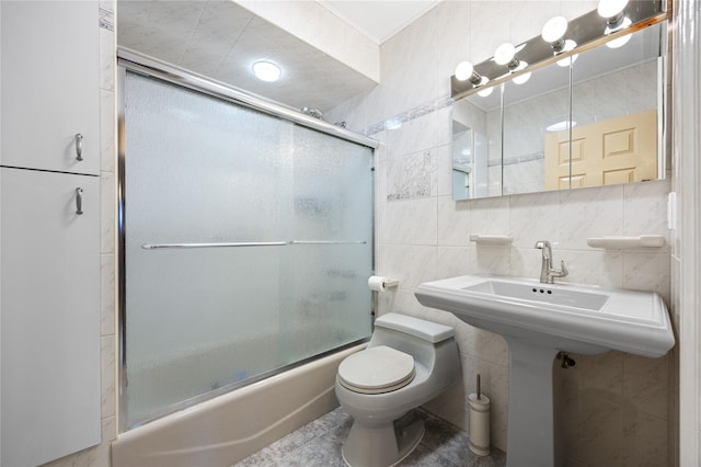 full bathroom with tile patterned floors, toilet, tasteful backsplash, combined bath / shower with glass door, and tile walls