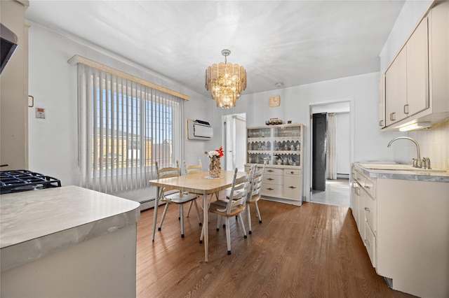 dining area featuring a notable chandelier, wood finished floors, and a wall mounted AC