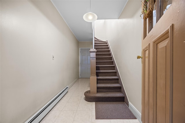 stairway featuring a baseboard heating unit, tile patterned floors, and baseboards