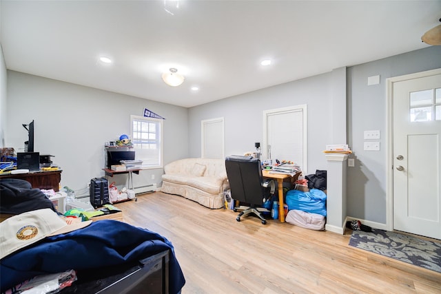 bedroom with recessed lighting, wood finished floors, baseboards, and a baseboard radiator