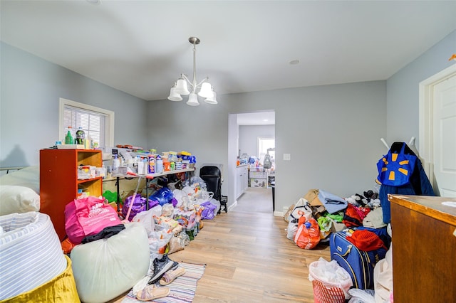 game room with a notable chandelier, wood finished floors, baseboards, and a wealth of natural light