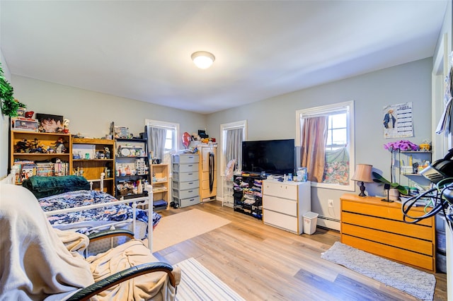 living area with a baseboard heating unit and wood finished floors