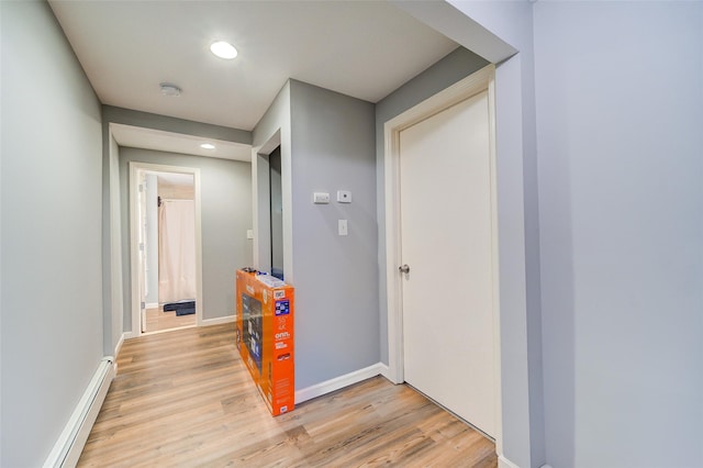 hallway featuring recessed lighting, light wood-style floors, baseboards, and a baseboard radiator