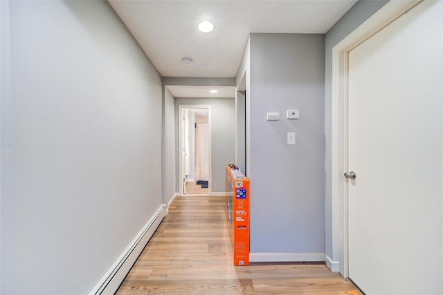 hallway with recessed lighting, a baseboard radiator, baseboards, and light wood finished floors