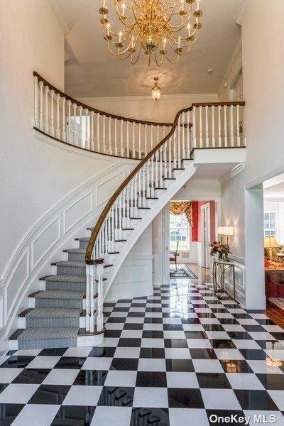 foyer with crown molding, a decorative wall, and plenty of natural light