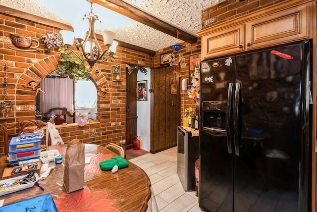 kitchen featuring beam ceiling, black fridge, brick wall, and an inviting chandelier