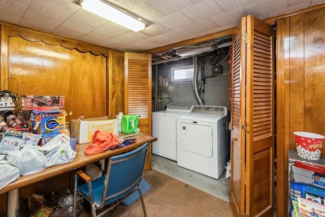 clothes washing area featuring laundry area, wooden walls, and separate washer and dryer