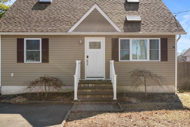 view of exterior entry featuring a shingled roof