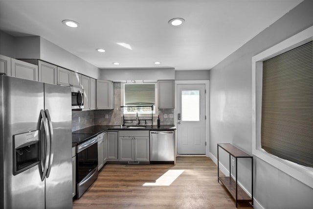 kitchen featuring dark countertops, gray cabinets, appliances with stainless steel finishes, and dark wood-type flooring