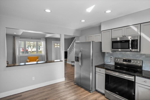 kitchen featuring tasteful backsplash, baseboards, recessed lighting, appliances with stainless steel finishes, and light wood-style floors