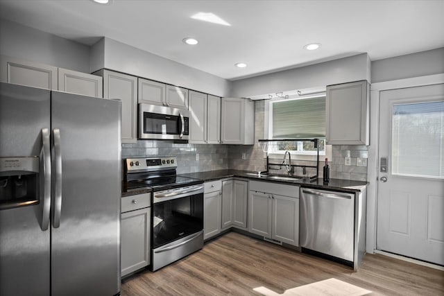 kitchen with stainless steel appliances, gray cabinetry, and dark wood-style flooring