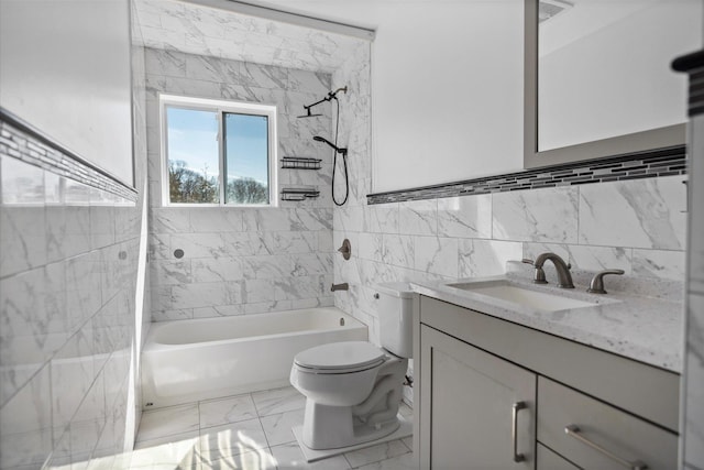 bathroom featuring toilet, vanity, bathtub / shower combination, marble finish floor, and tile walls