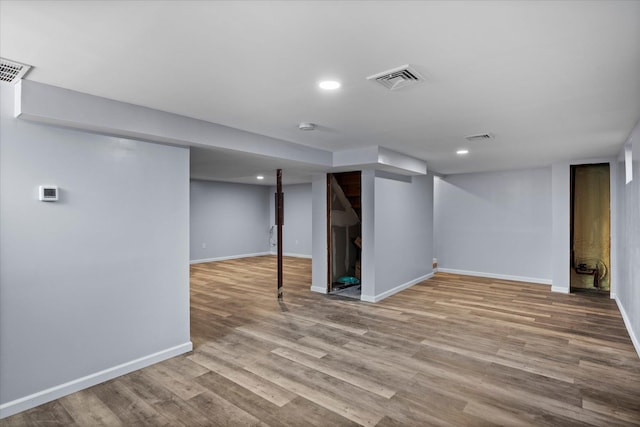 finished below grade area featuring recessed lighting, visible vents, baseboards, and wood finished floors