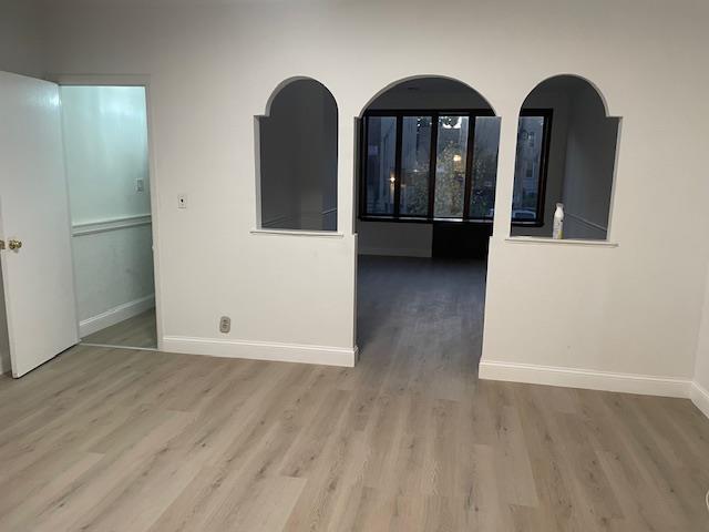 spare room featuring wood finished floors and baseboards