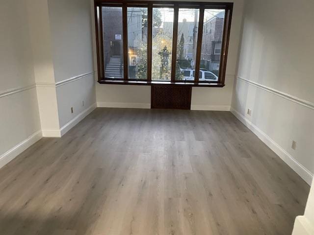 empty room with wood finished floors and baseboards