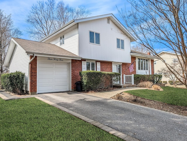 tri-level home featuring a front yard, an attached garage, brick siding, and driveway